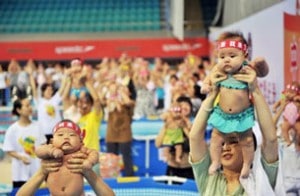 Chinese babies held up by their parents during an event